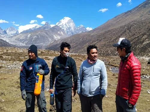Trekking guides carrying portable oxygen cylinder for altitude sickness prevention on Everest Base Camp trek