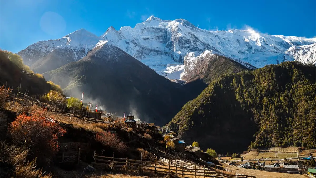 Upper Pisang village with Annapurna II snow-capped peak and autumn forest Annapurna Circuit Nepal